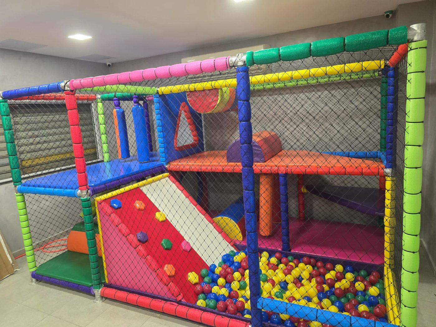 Brinquedão com parede de escalada, piscina de bolinhas e nets coloridas