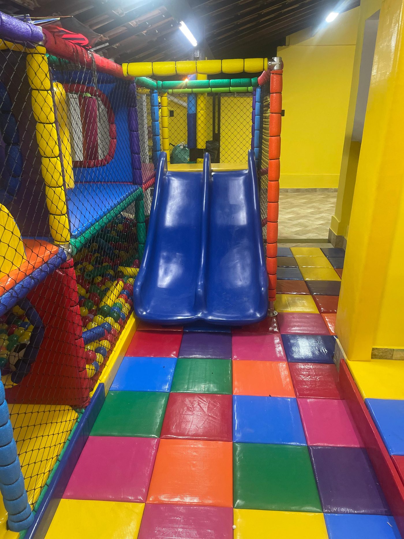 Escorrega azul duplo com piso colorido em restaurante